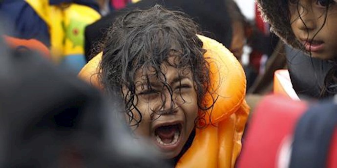  'A Syrian refugee child terrified while crossing part of the Aegean Sea from Turkey to the Greek island of Lesbos in a overcrowded dinghy '
