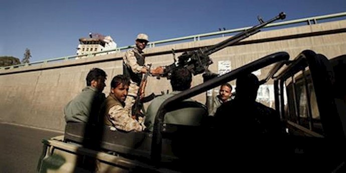  'Houthi militants ride on the back of a patrol truck.'