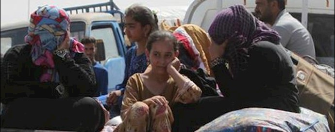  'Residents from Ramadi who fled their homes sit in the back of a truck as they wait  to enter Baghdad'