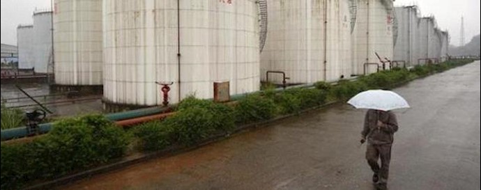  'An employee walks past gasoline storage tanks in Suining, Sichuan province '