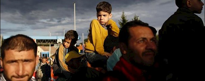  'Refugees line up to cross the border from Croatia to the Slovenian village in Harmica, Croatia'