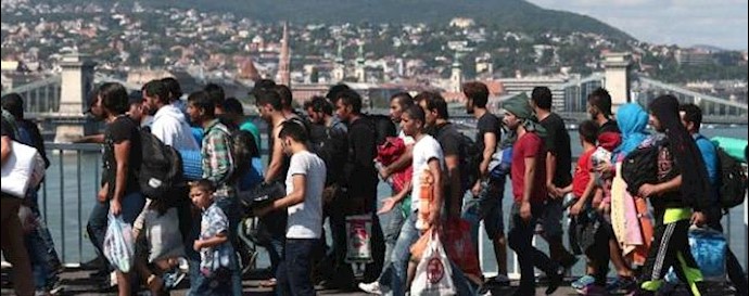  'Hundreds of migrants walk after leaving the transit zone of the Budapest train station, on September 4, 2015'