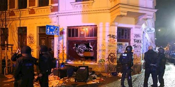  'German riot police stand in front of a damaged building in the Connewitz district of Leipzig, on January 11, 2016'