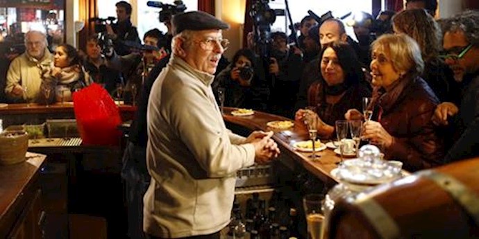  'Owner of the Carillon restaurant welcomes customers during the re-opening exactly two months after the November attacks, in Paris'