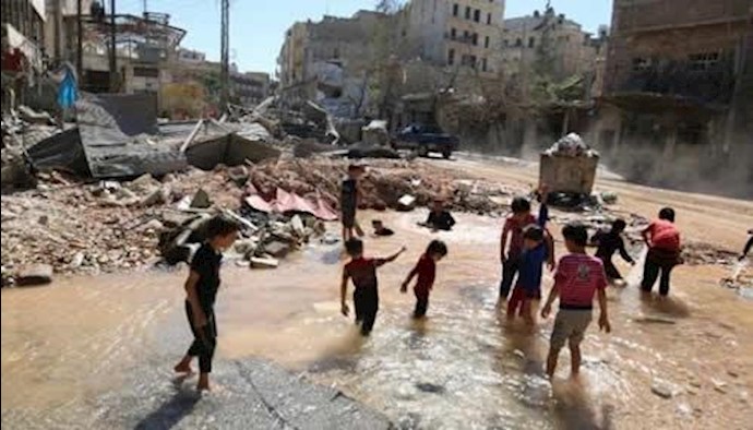  'Children play with water from a burst pipe after an airstrike. At least 114 children have been killed in east Aleppo during September'