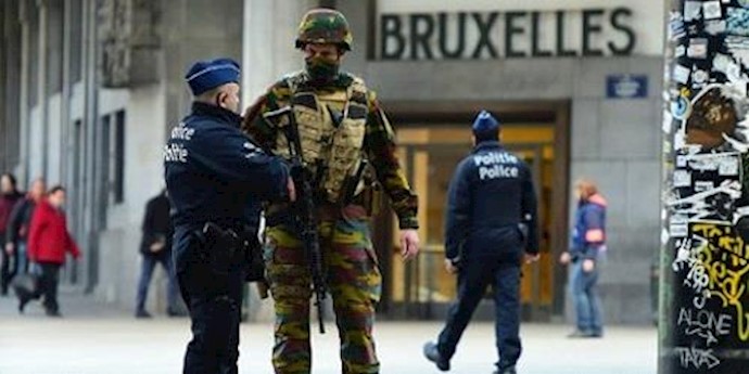  'A Belgian soldier speaks to a police officer outside Brussels Central Station following attacks in Brussels on March 22, 2016'