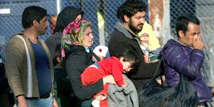  'Refugees from Afghanistan wait to take a bus during a police operation at the Greek-Macedonian border '