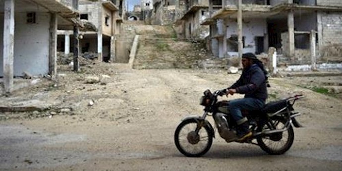  'A Syrian man rides a motorbike past destroyed buildings in rebel-held town of Talbiseh on the northern outskirts of Homs '