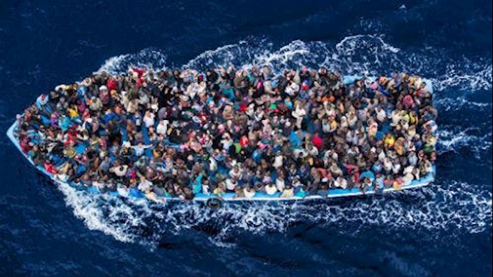  'Hundreds of refugees and migrants aboard a fishing boat moments before being rescued by the Italian Navy'