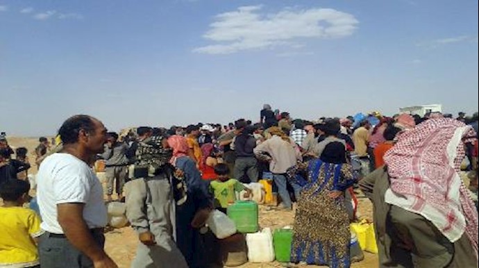 Syrian refugees at the border with Jordan receive water