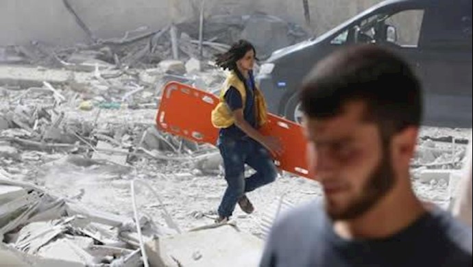  'A man runs with a stretcher in a damaged site after airstrikes on the rebel held al-Qaterji neighbourhood of Aleppo, Syria September 21, 2016.'
