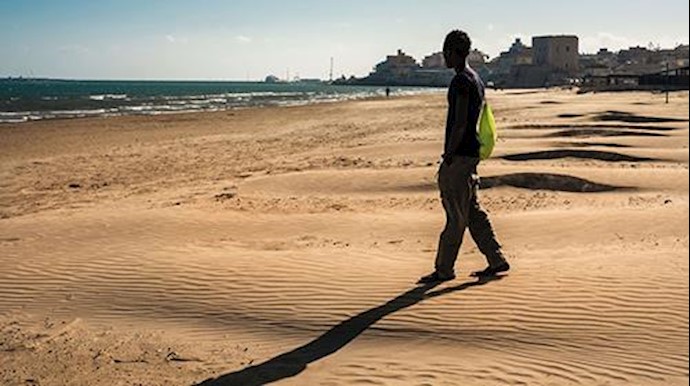  'A youngster walks onto the beach in Pozzallo, Sicily'