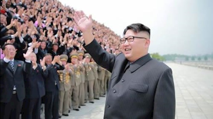  'North Korean leader Kim Jong Un waves as he participates in a photo session with officials'
