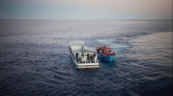  'Risking their lives to reach Europe from North Africa, a boatload of people are rescued in the Mediterranean Sea by the Italian Navy'