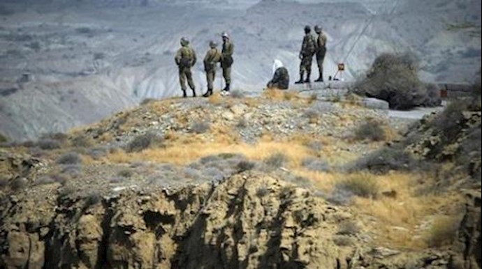  'Members of IRGC monitor an area as they stand on top of a hill while taking part in a war game in the Hormuz area of southern Iran '
