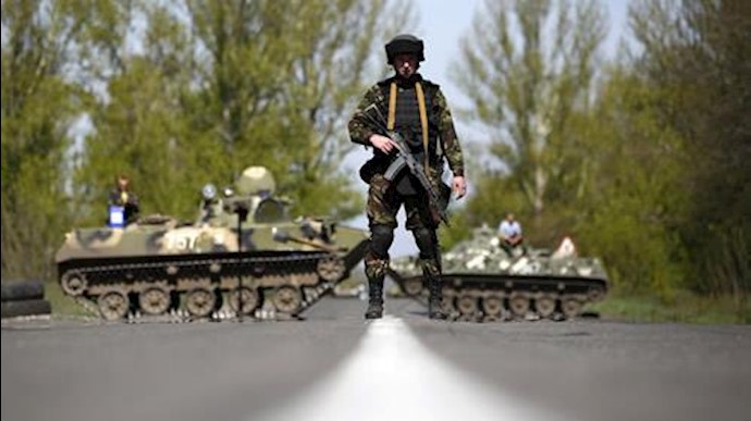  'File photo of a Ukrainian soldier in front of armoured personnel carriers at a check point in eastern Ukraine.'