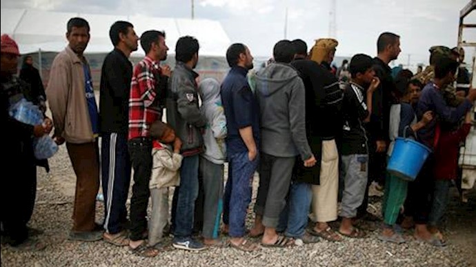  'Displaced Iraqis wait to get food supplies before entering at Hammam al-Alil camp south of Mosul on April 3, 2017'