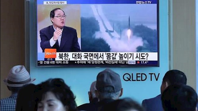  'People watch a television news programme, showing file footage of a North Korean missile launch, at a railway station in Seoul on May 14, 2017'