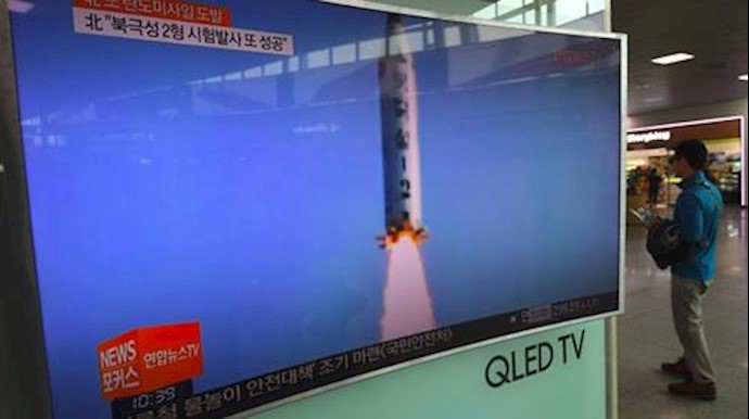  'A man walks past a television showing a news report on North Koreas latest missile test in Seoul'