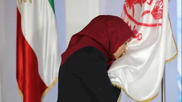  'Ms. Merrikhi paying respect to the PMOI Emblem at the great gathering of Iranian Opposition.'