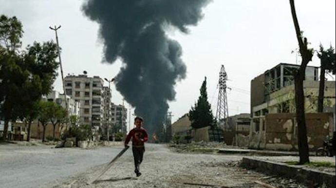  'A child runs along a street in front of clouds of smoke billowing following a reported air strike on Douma, March 20, 2018.'