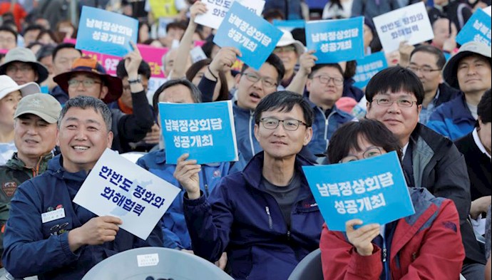  'People hold signs reading "successful summit between South and North Koreas" during the welcoming event for the summit between South Korea and North Korea in downtown Seoul, South Korea'