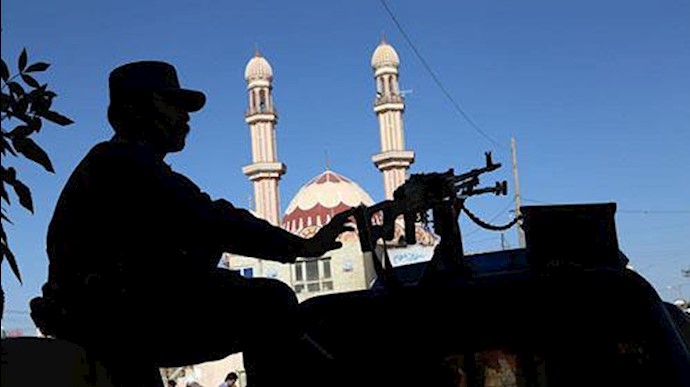  'An Afghan security personnel stands guard outside a mosque as residents offer prayers at the start'