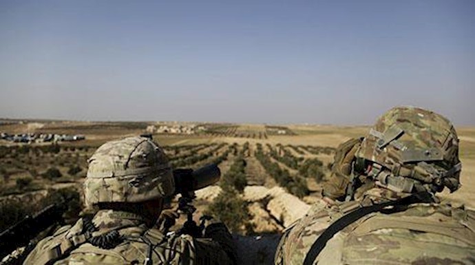  'American troops looked out toward the border with Turkey from a small outpost near the town of Manbij, northern Syria, in February'