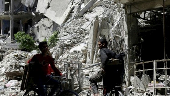  'Syrians cycle along a damaged street in Douma'