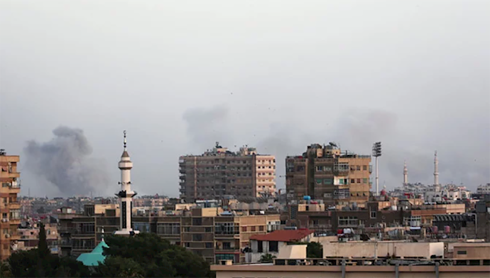  'Smoke rises from Yarmouk Palestinian camp in Damascus. Air strikes and shelling hit the Palestinian refugee camp and Al-Hajjar Al-Aswad area, part of a small enclave divided between warring militants and other rebels south of the capital.'