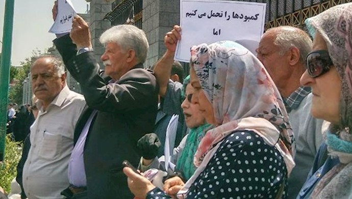  'A group of retired school teachers gathered in front of the Parliament '